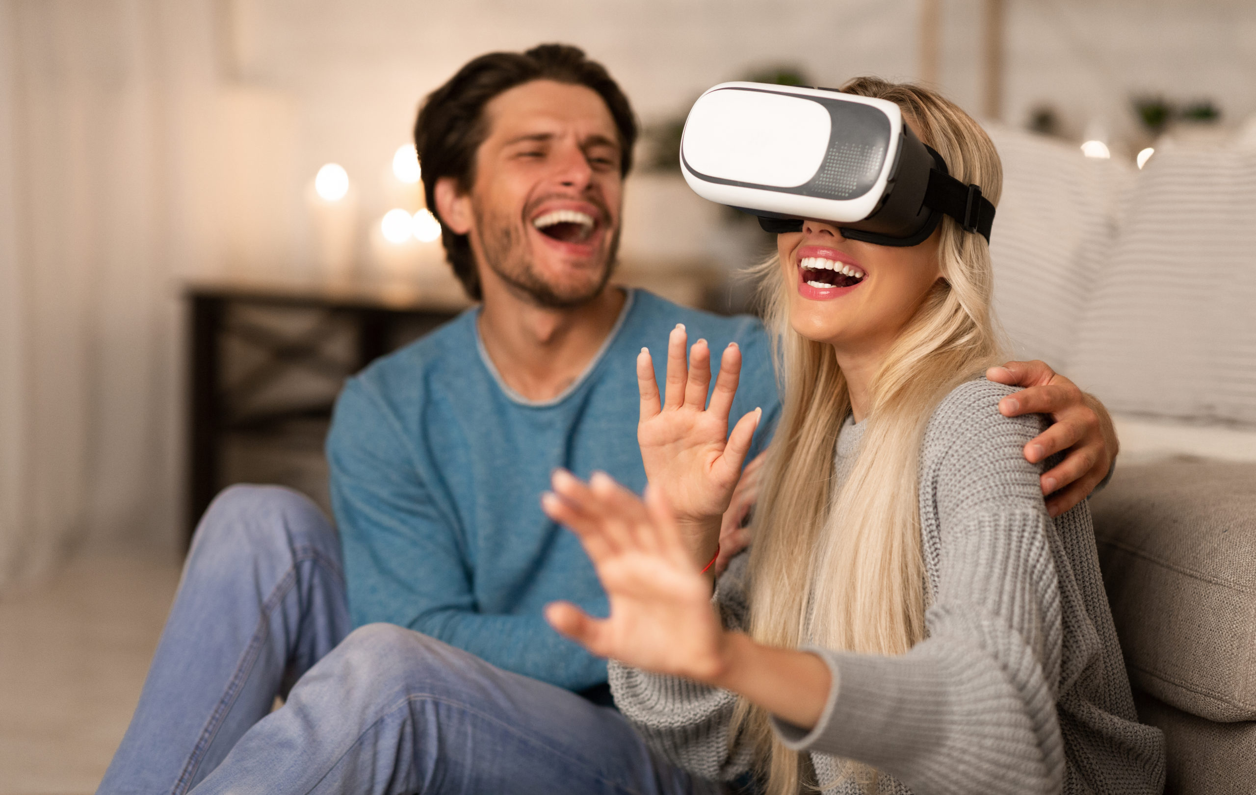 Modern Date. Millennial Couple Using VR Headset Experiencing Virtual Reality At Home At Night.